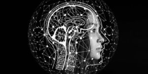 La imagen ilustra cómo la IA se usa en el diseño gráfico, el rostro robótico representa la IA, el mapeo digital la recopilación de datos y el dibujo de cerebro el pensamiento humano creativo. Juntos, trabajan para generar diseños innovadores.
